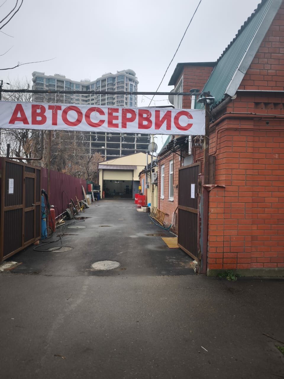 Въезд во двор под вывеской «Автосервис»